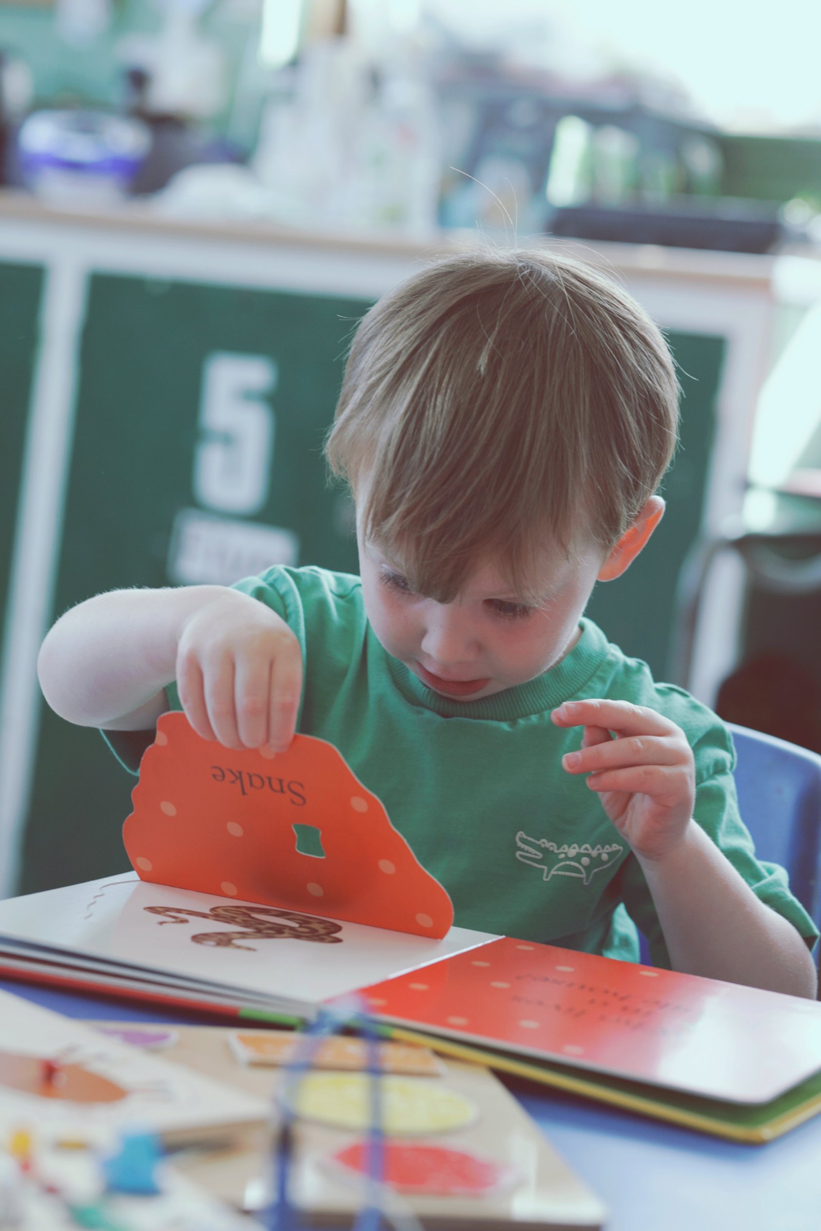 Child reading a book during nursery photography session in Cullercoats